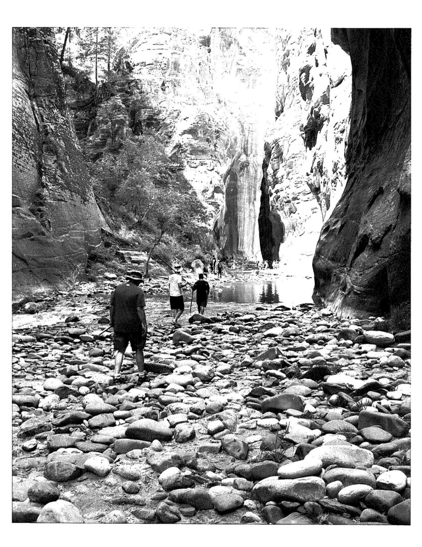 A black and white photo of people walking in the rocks