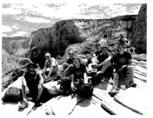 A group of people sitting on top of a rock.
