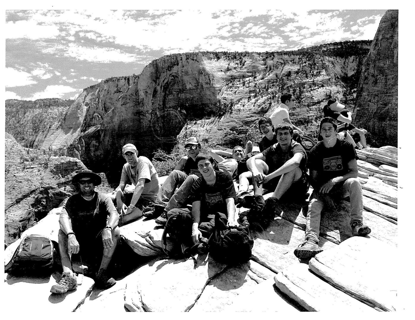 A group of people sitting on top of a rock.