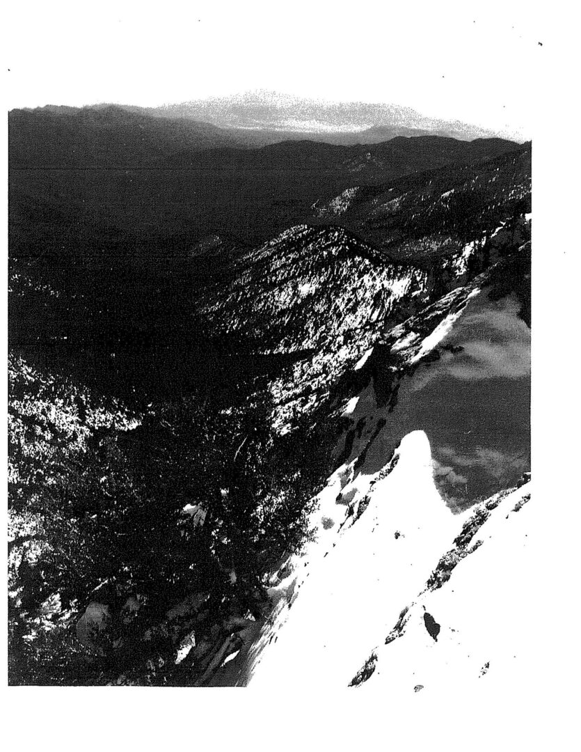 A black and white photo of mountains with snow on the ground.