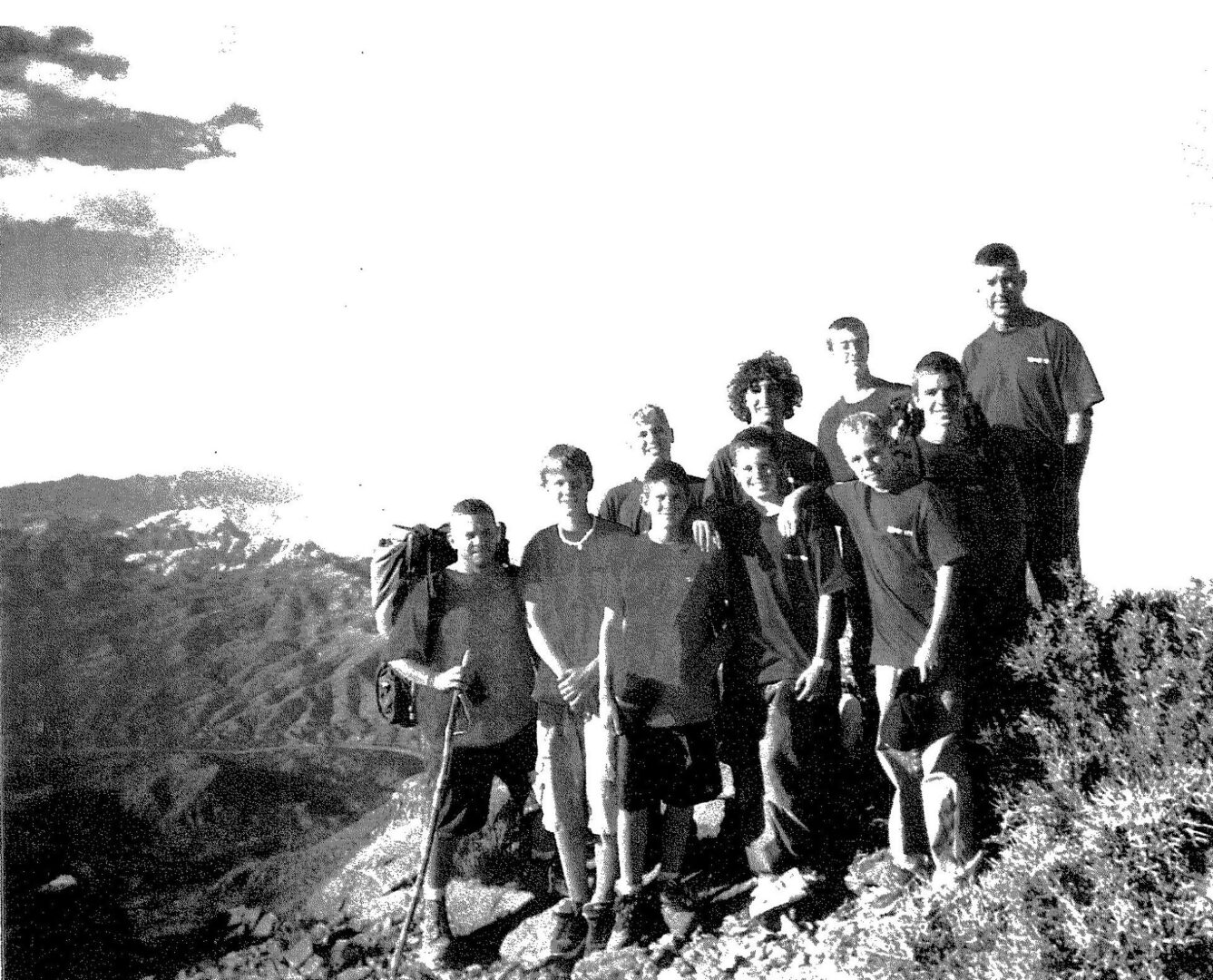 A group of people standing on top of a hill.