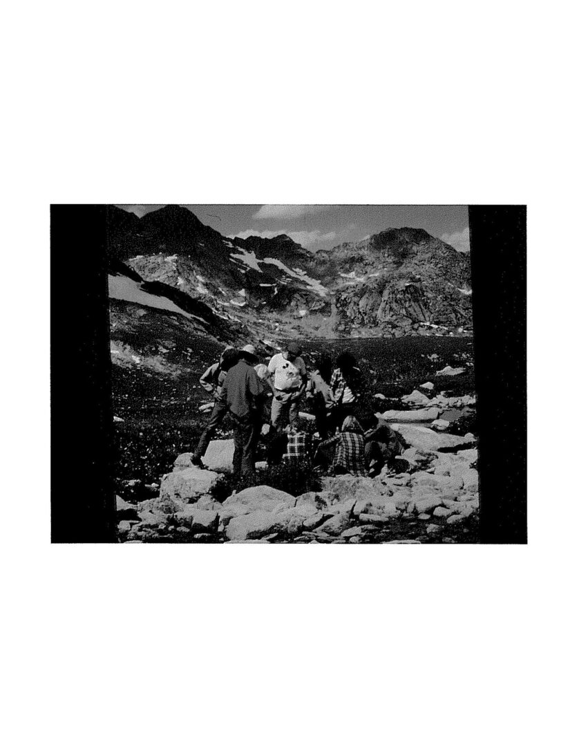 A black and white photo of people in the mountains