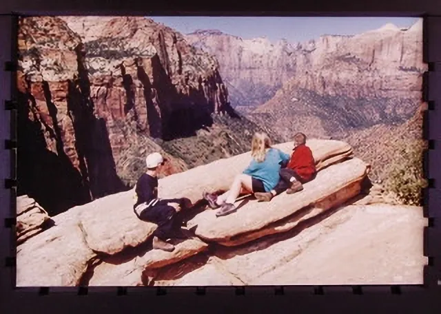 A group of people sitting on top of a rock.