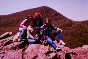A group of people sitting on top of a rock.