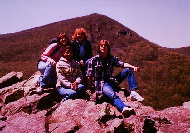 A group of people sitting on top of a rock.