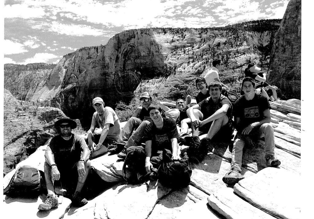 A group of people sitting on top of a rock.